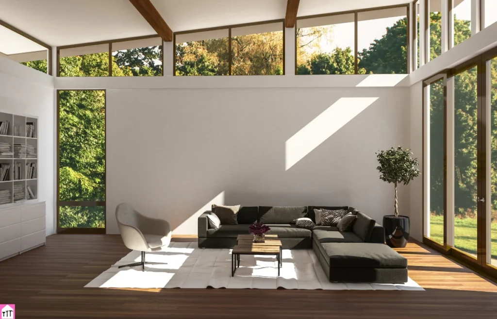 Bright and airy living room with large windows, neutral tones, and natural light streaming in, highlighting minimalistic furniture and greenery outside.